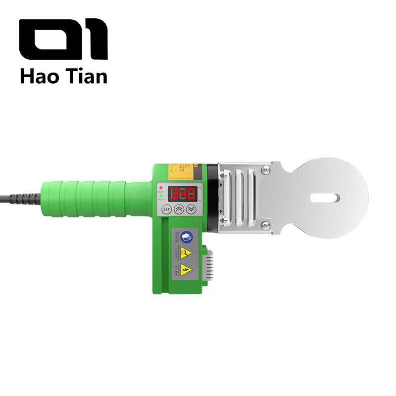 A close-up of the Haotian handheld PPR welder. The machine is green with a non-slip handle. It features a digital temperature controller with a display showing '340', red RDY (Ready) and green HEAT (Heating) indicators, as well as 'SET' and up and down arrow buttons. An oval silver heating plate is mounted on the front of the welder. Safety warning labels regarding high temperatures and electrical hazards are affixed to the machine.